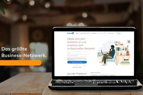 Auf einem Laptop ist der Anmeldebildschirm von LinkedIn zu sehen. Daneben steht: Das größte Business-Netzwerk.